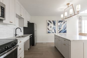 A kitchen with white cabinets and a black stove top oven